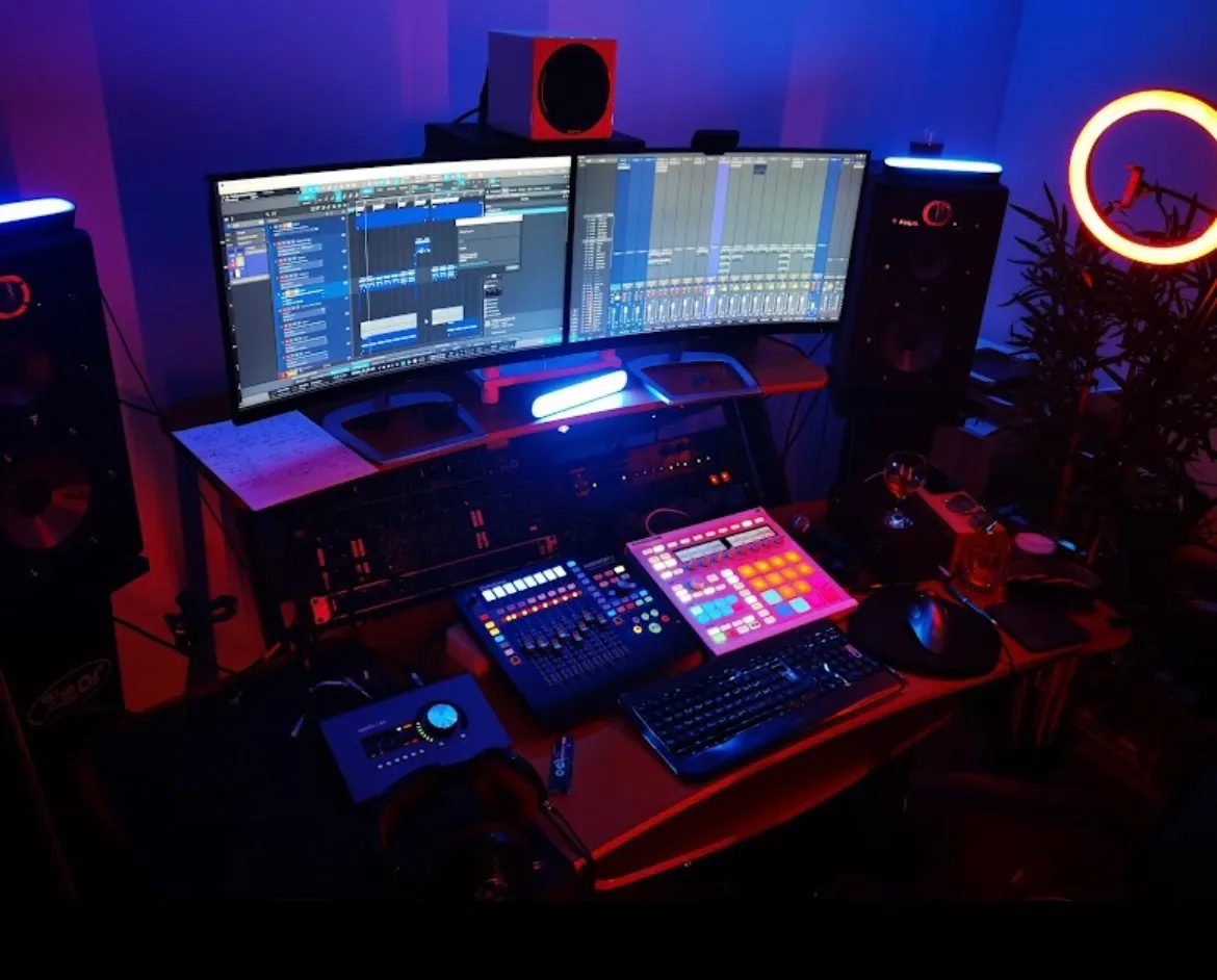 Poste de production musicale du Purple Studio avec double écran, MPC et contrôleurs